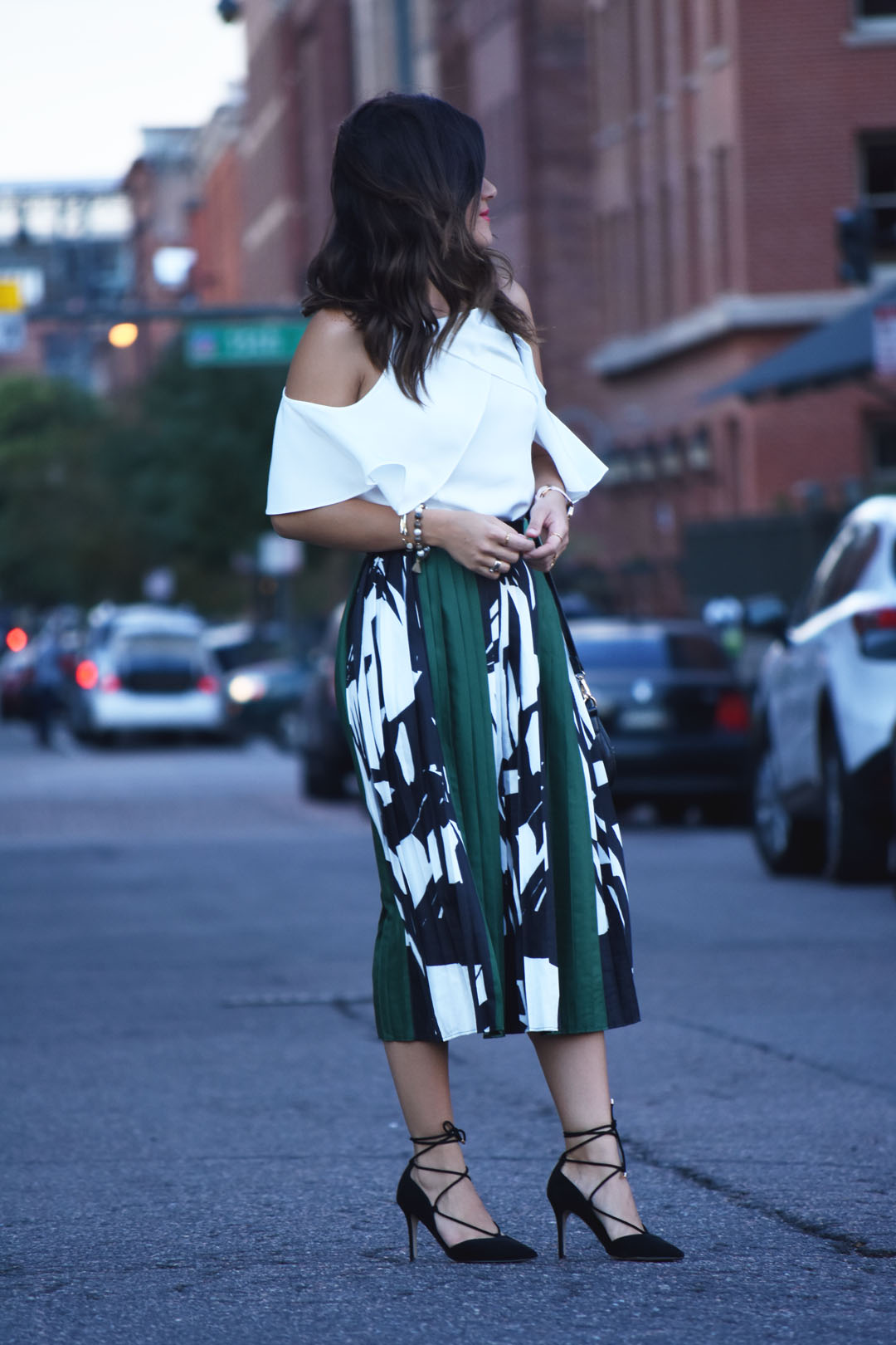 Carolina Hellal of Chic Talk wearing a pleated green skirt and cold shoulder top - PLEATED MIDI SKIRT AND COLD SHOULDER TOP by popular Denver fashion blogger Chic Talk
