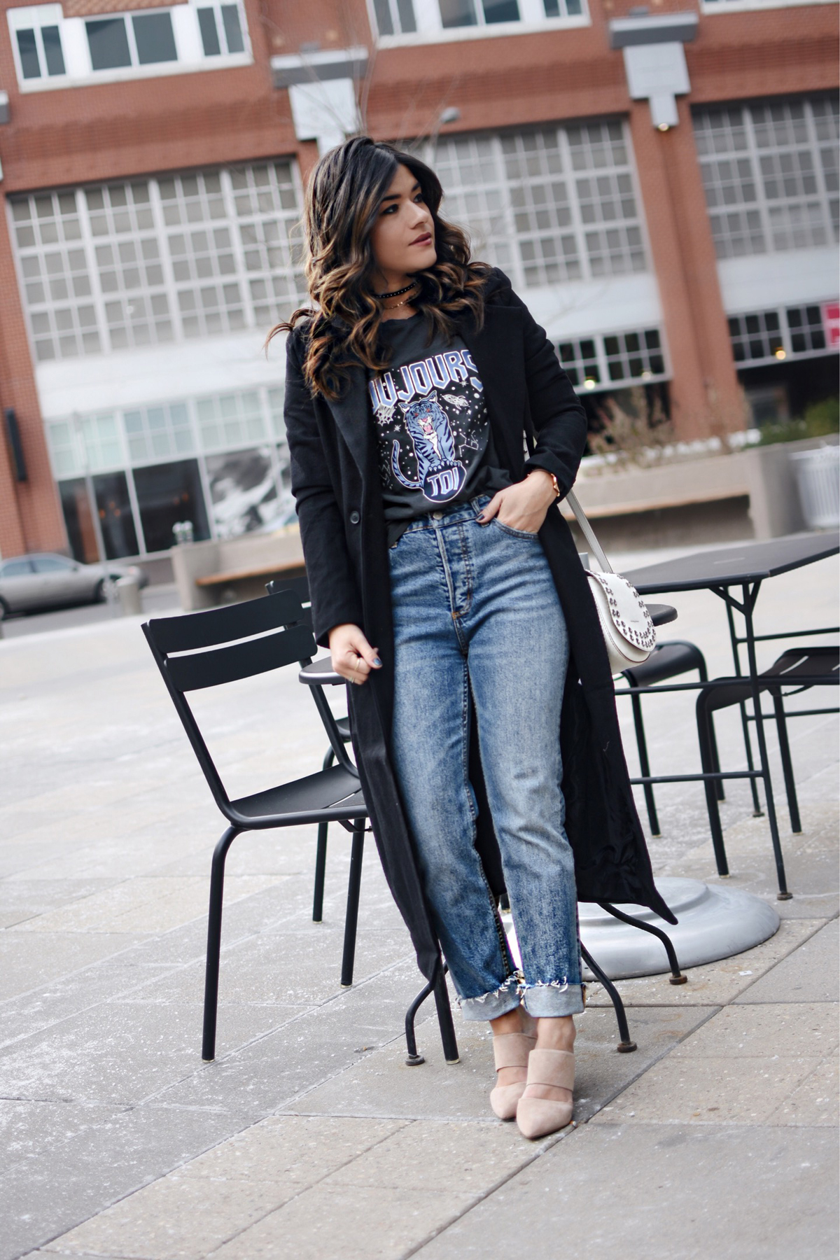 Carolina Hellal of Chic Talk wearing an H&M graphic t-shirt, H&m girlfriend jeans, Frey company white crossbody bag, and NA-KD fashion mules and black coat. - HOW TO STYLE GIRLFRIEND JEANS by popular Denver fashion blogger Chic Talk