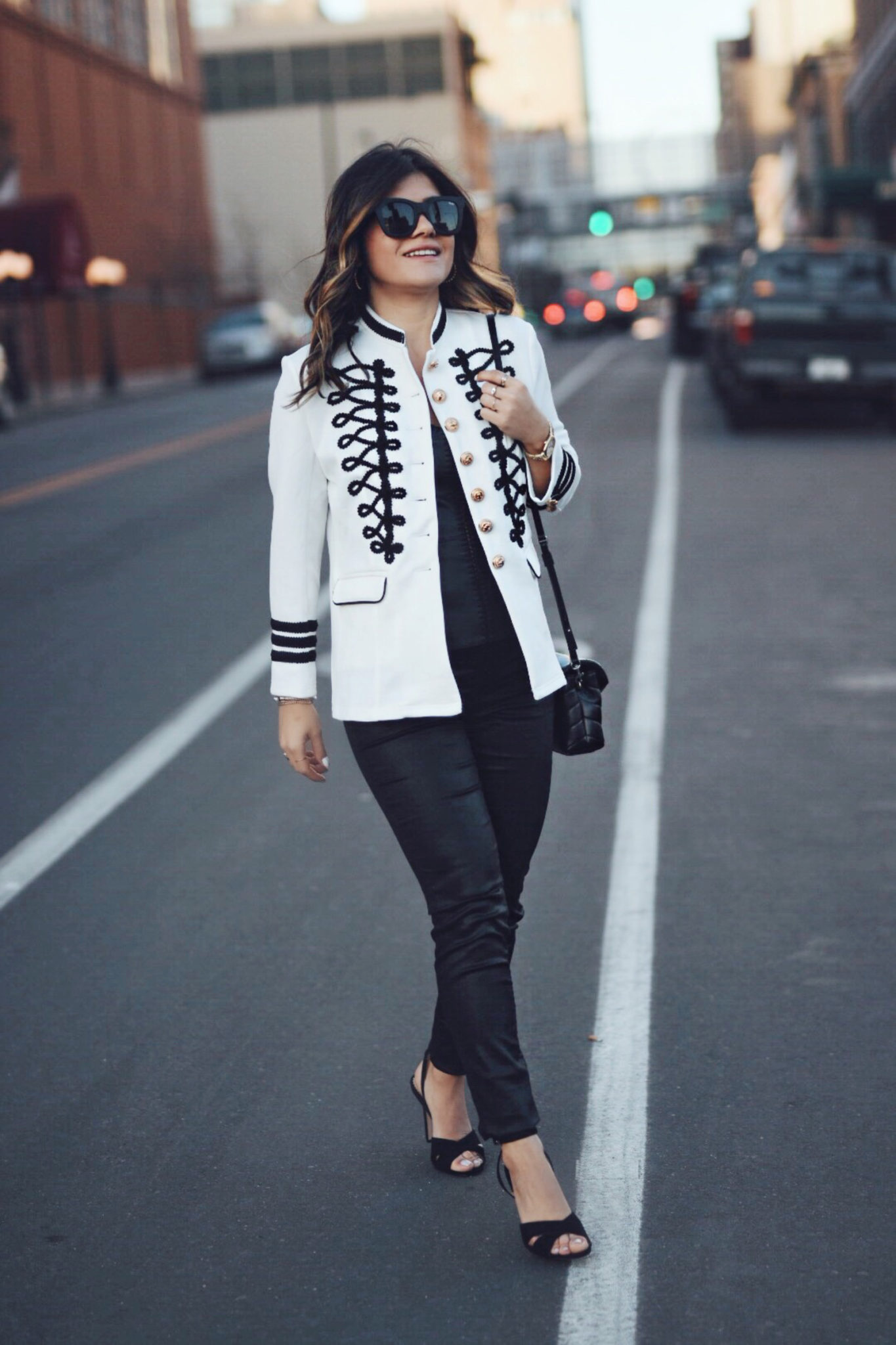 Carolina Hellal wearing a white military jacket, faux leather black tank top, YSL crossbody bag, quay sunglasses and Sam Edelman sandals - STYLING A WHITE MILITARY JACKET by popular Denver fashion blogger Chic Talk