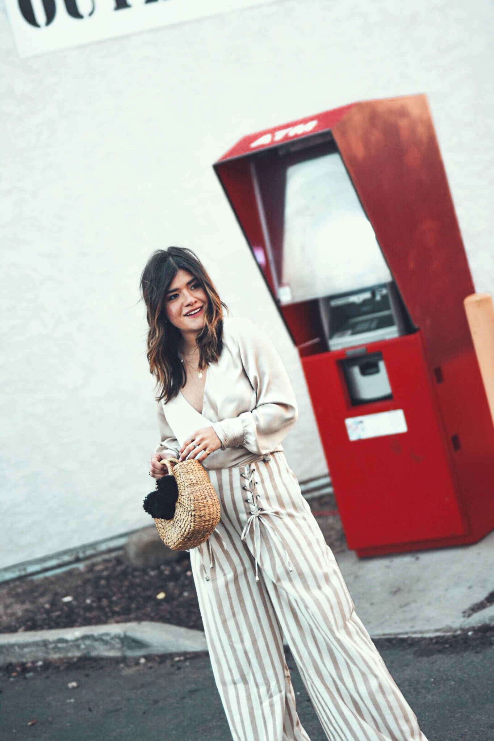 Carolina Hellal wears the Chriselle Lim x J.O.A wide leg pants, h&m silk top and JADEtribe mini pom pom bag - STYLING WIDE LEG PANTS FOR SPRING by popular Denver fashion blogger Chic Talk