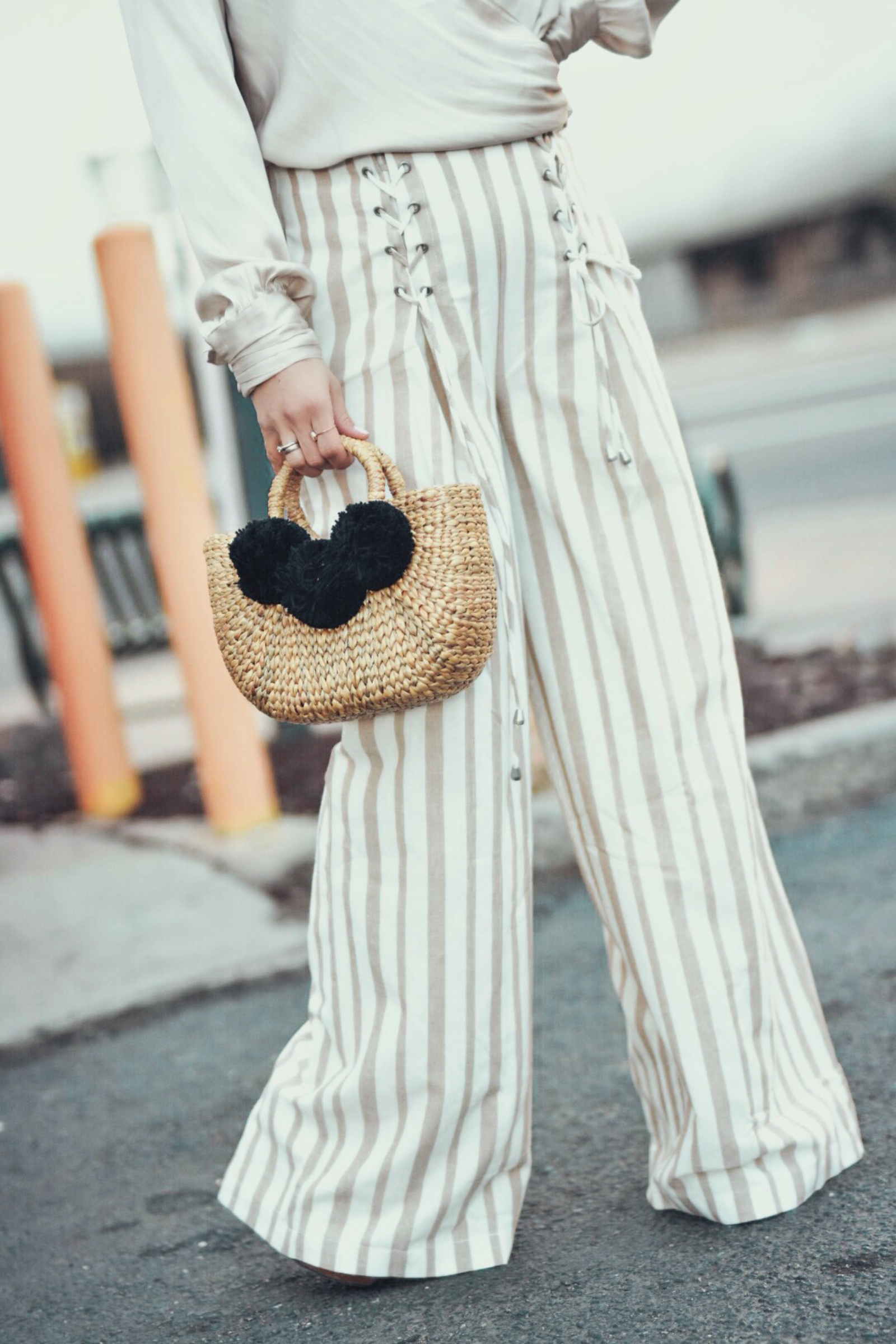 Carolina Hellal wears the Chriselle Lim x J.O.A wide leg pants, h&m silk top and JADEtribe mini pom pom bag - STYLING WIDE LEG PANTS FOR SPRING by popular Denver fashion blogger Chic Talk