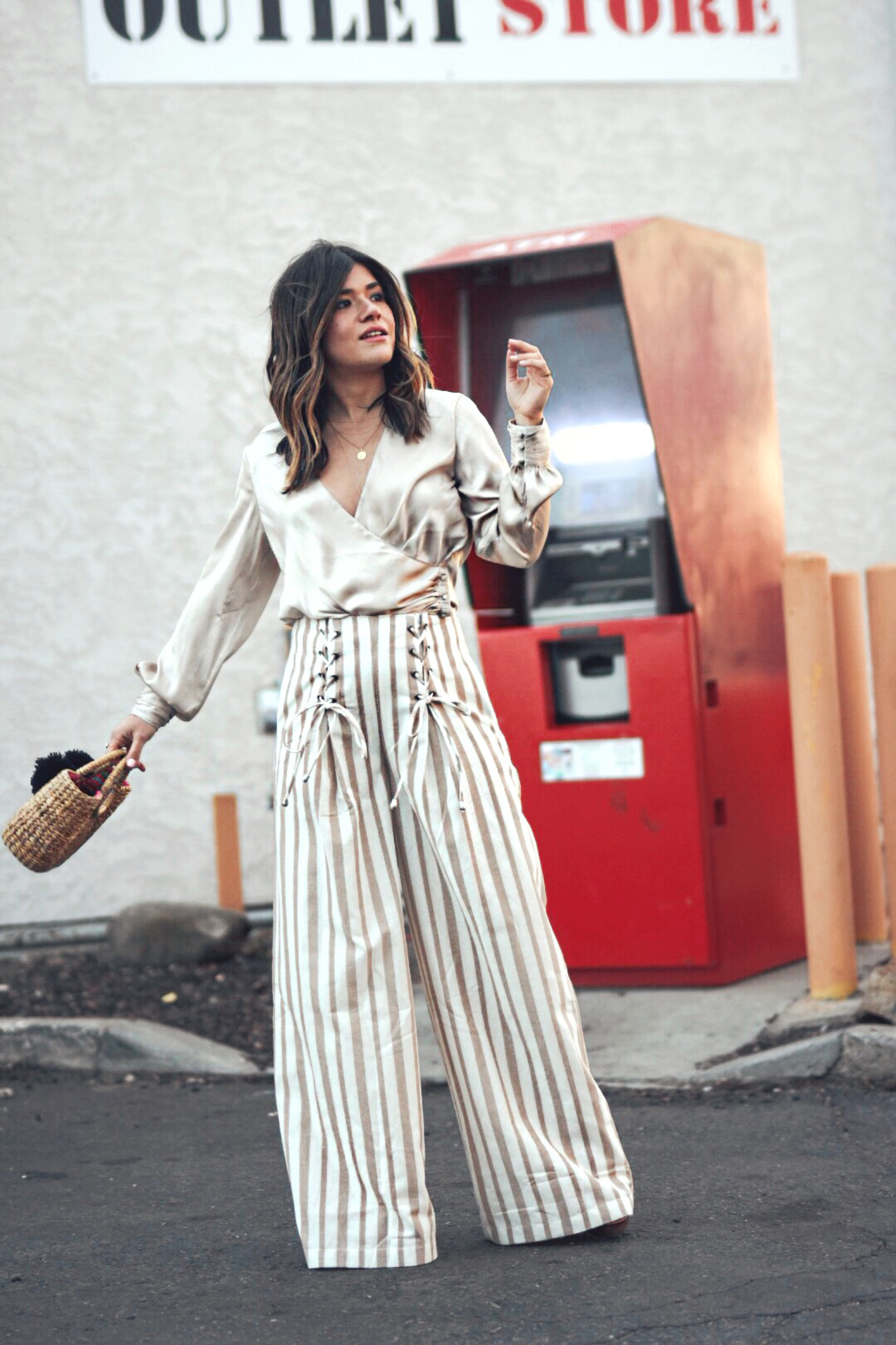 Carolina Hellal wears the Chriselle Lim x J.O.A wide leg pants, h&m silk top and JADEtribe mini pom pom bag - STYLING WIDE LEG PANTS FOR SPRING by popular Denver fashion blogger Chic Talk